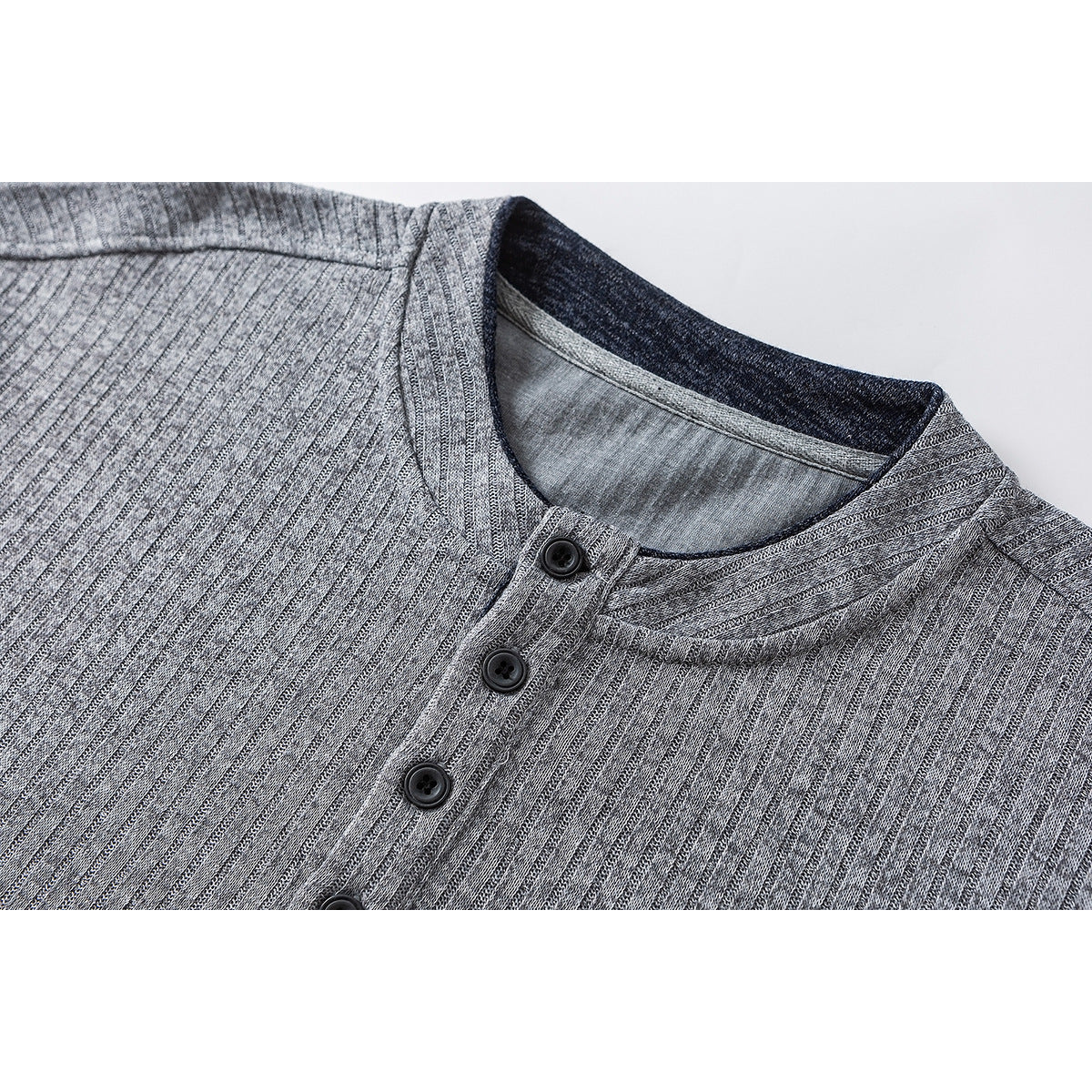 Close-up of a gray ribbed shirt's band collar and dark four-button placket.