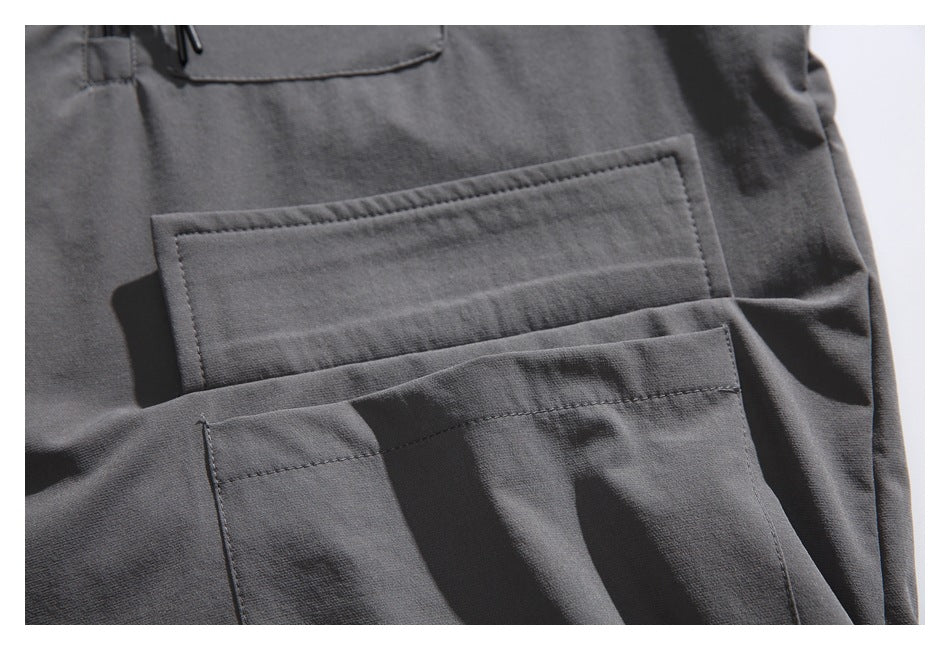 Close-up of layered rectangular pockets on a charcoal gray garment.
