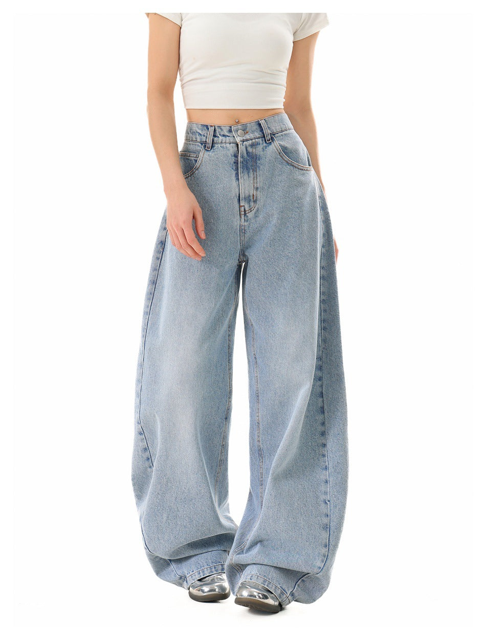 Model wearing light-wash, very wide-leg jeans with a white cropped T-shirt, slightly angled front view.