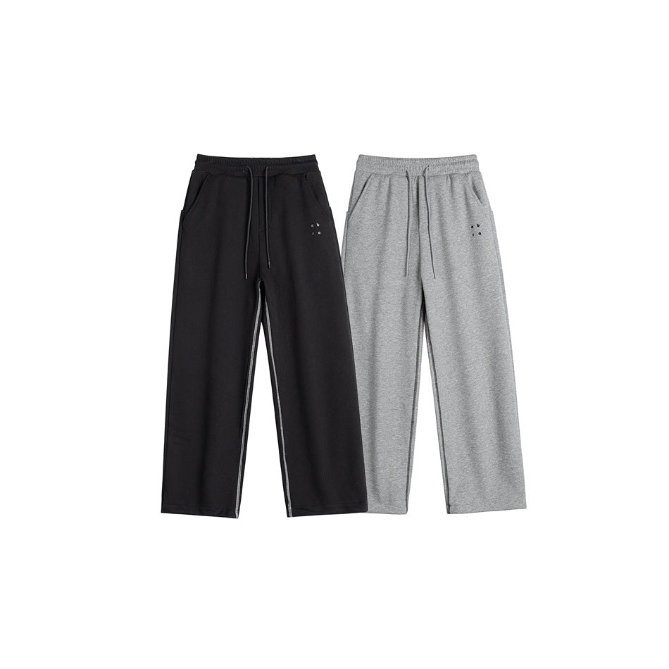 Front view of relaxed straight-leg pants in black and heather gray, with drawstrings and side pockets.