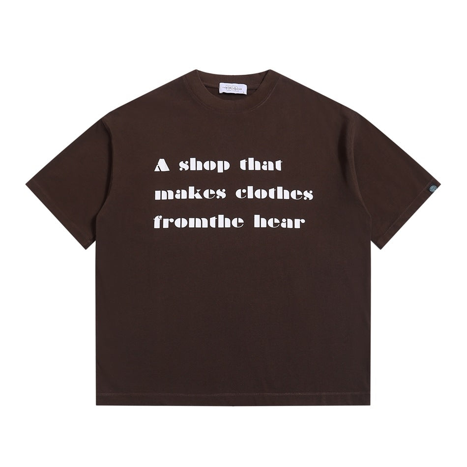 Brown short-sleeve crew-neck T-shirt with white block-letter slogan print on the front, flat lay