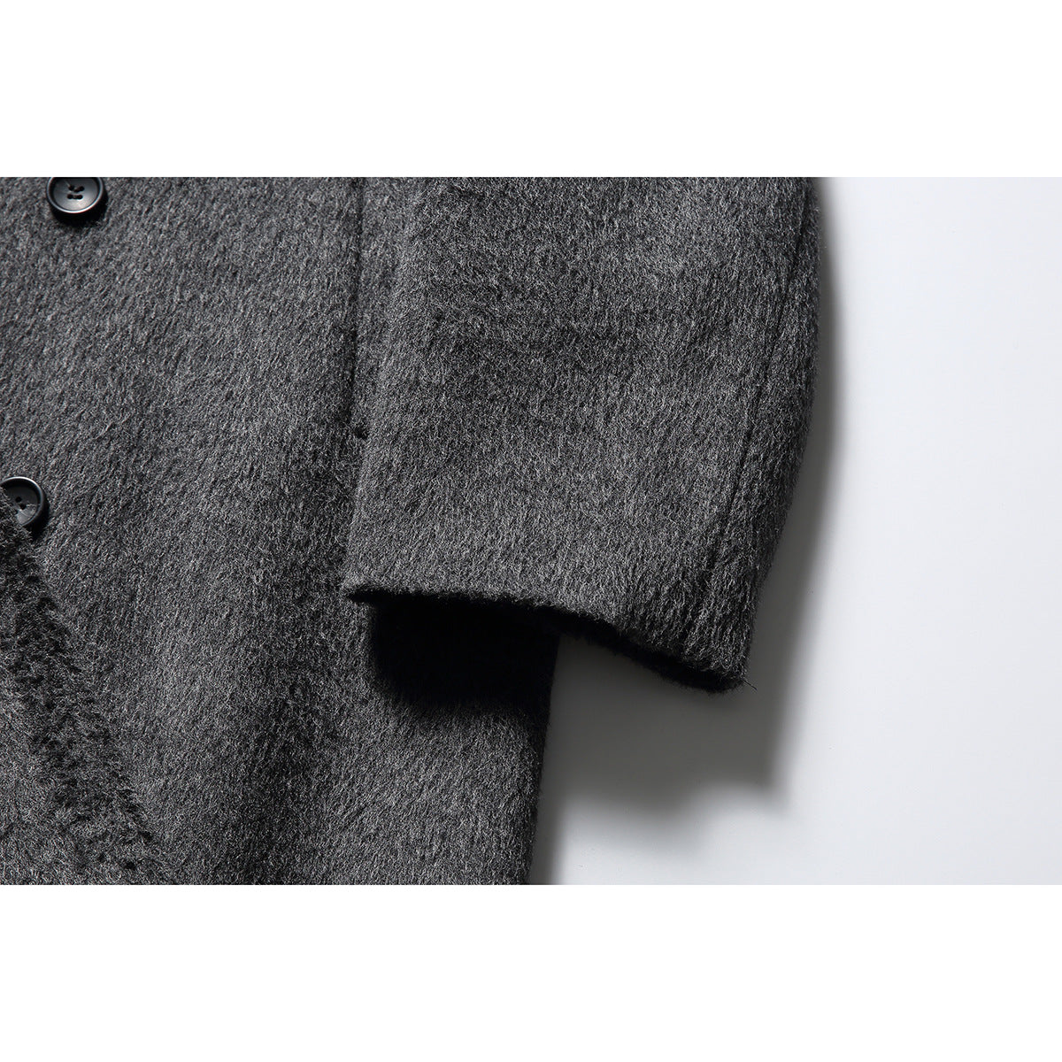 Close-up of the charcoal coat's textured sleeve cuff and black buttons.