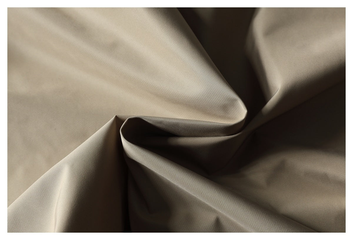 Close-up of smooth taupe fabric draped into folds.