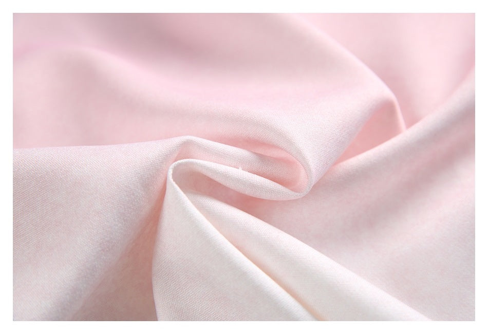 Close-up of pale pink garment fabric gathered into soft folds, showing its surface and drape.