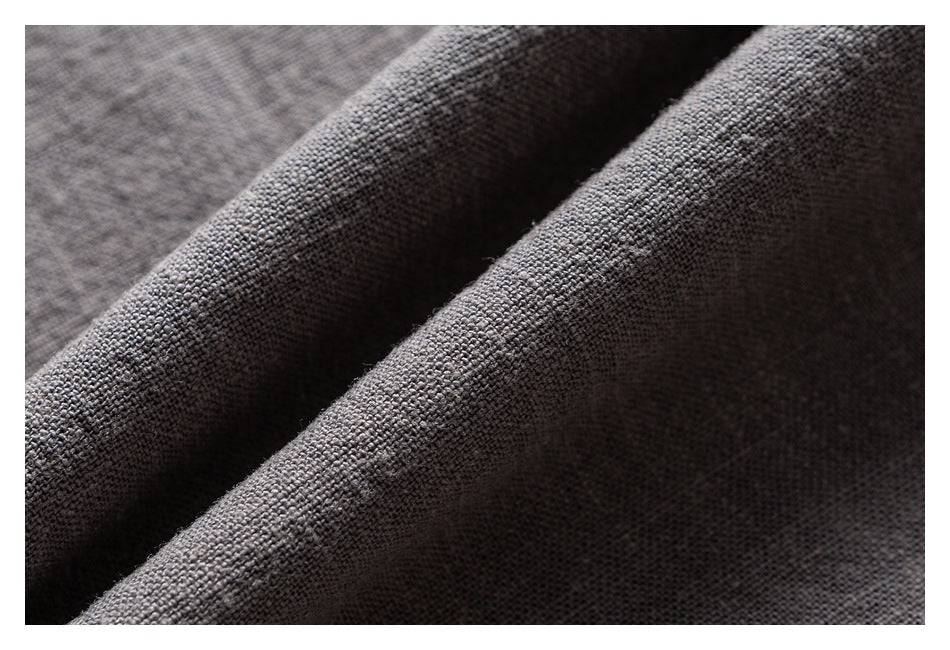 Macro view of the coarse, textured weave of dark gray shirt fabric.