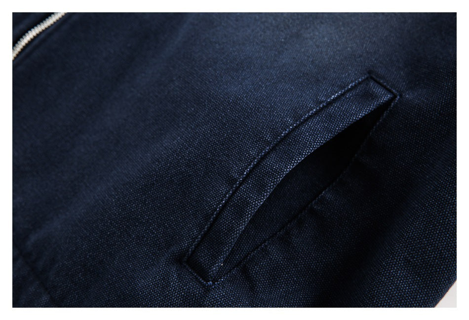 Close-up of a slanted welt pocket on a textured navy garment.