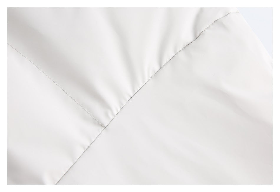 Close-up showing intersecting stitched seams on pale gray fabric.