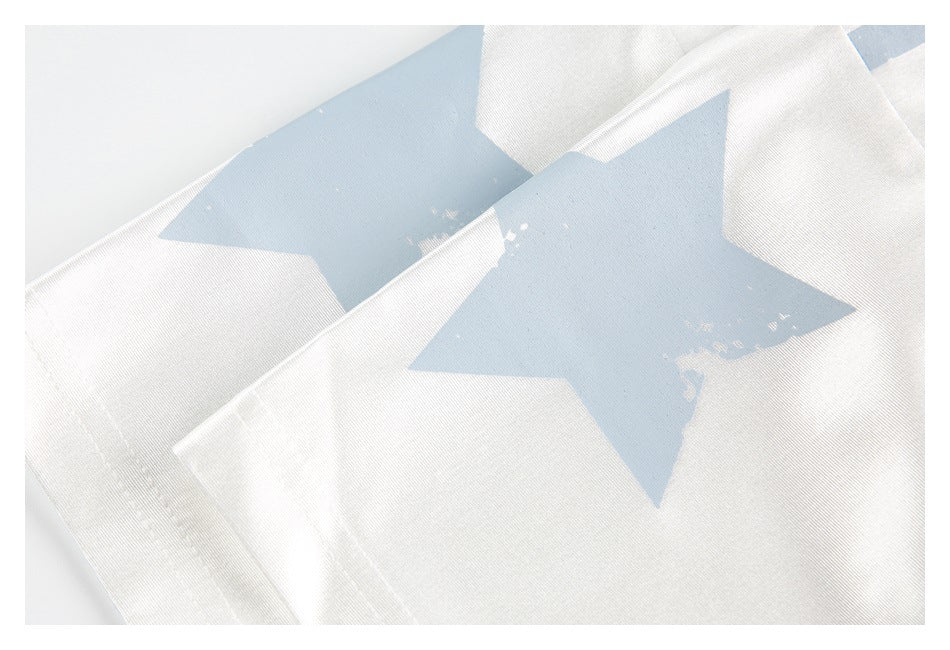 Close-up of a white garment printed with a large distressed pale blue star.