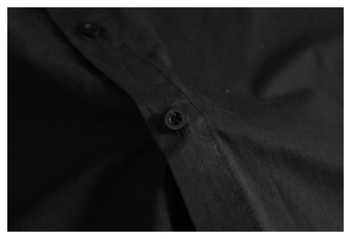 Close-up of a black shirt's button placket, showing two black buttons and stitching.