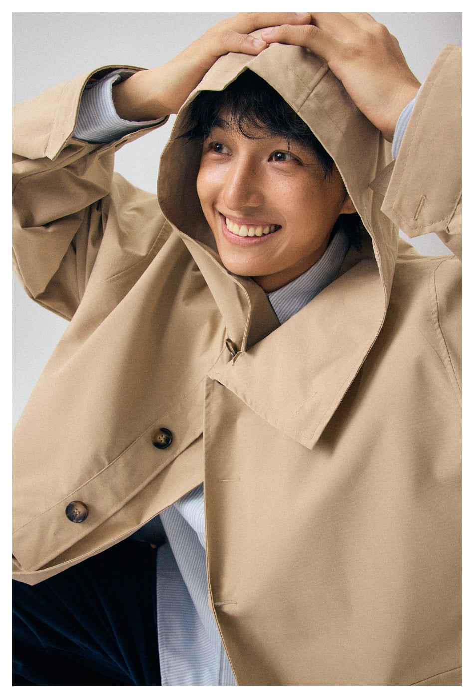 Close-up of the beige coat’s oversized hood, wide collar, and buttoned front.