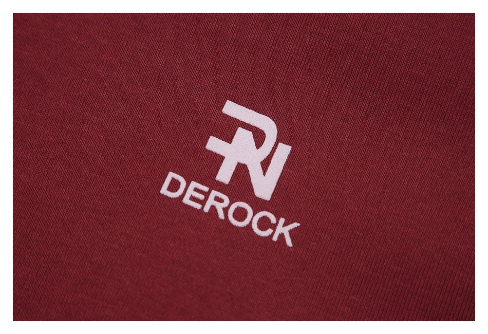 Close-up of a pale DERОCK logo printed on burgundy hoodie fabric.