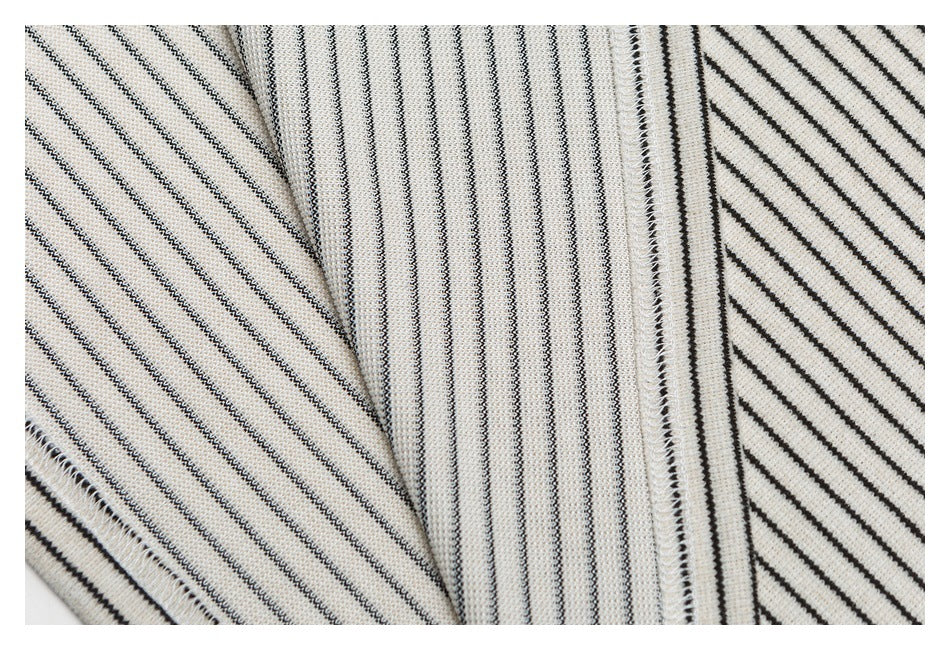 Close-up of striped cream knit fabric with black lines and visible overlocked seams between folded panels.