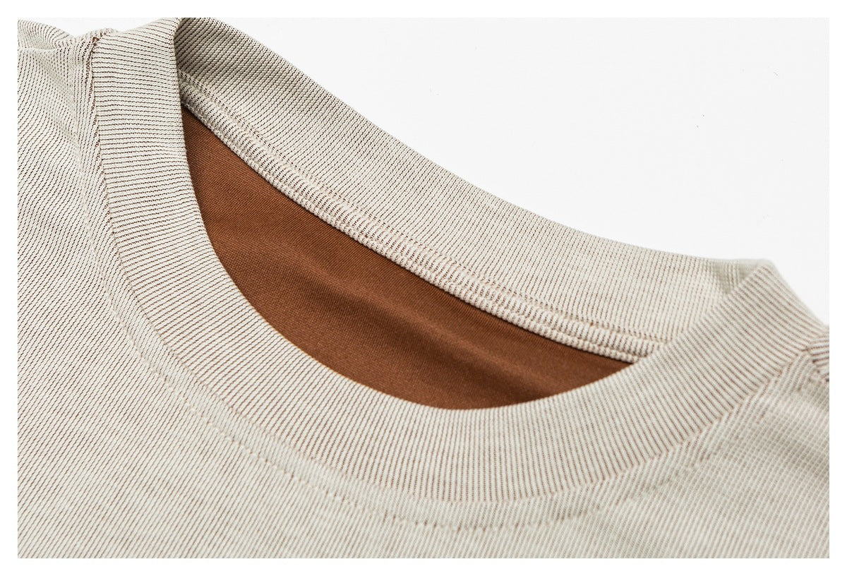 Close-up of the cream ribbed garment's round neckline with brown inner facing.