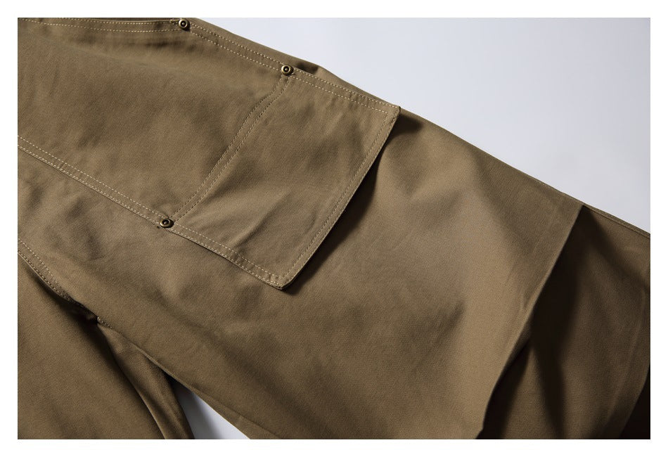 Close-up of khaki trousers with a large buttoned flap cargo pocket and stitched leg panels.
