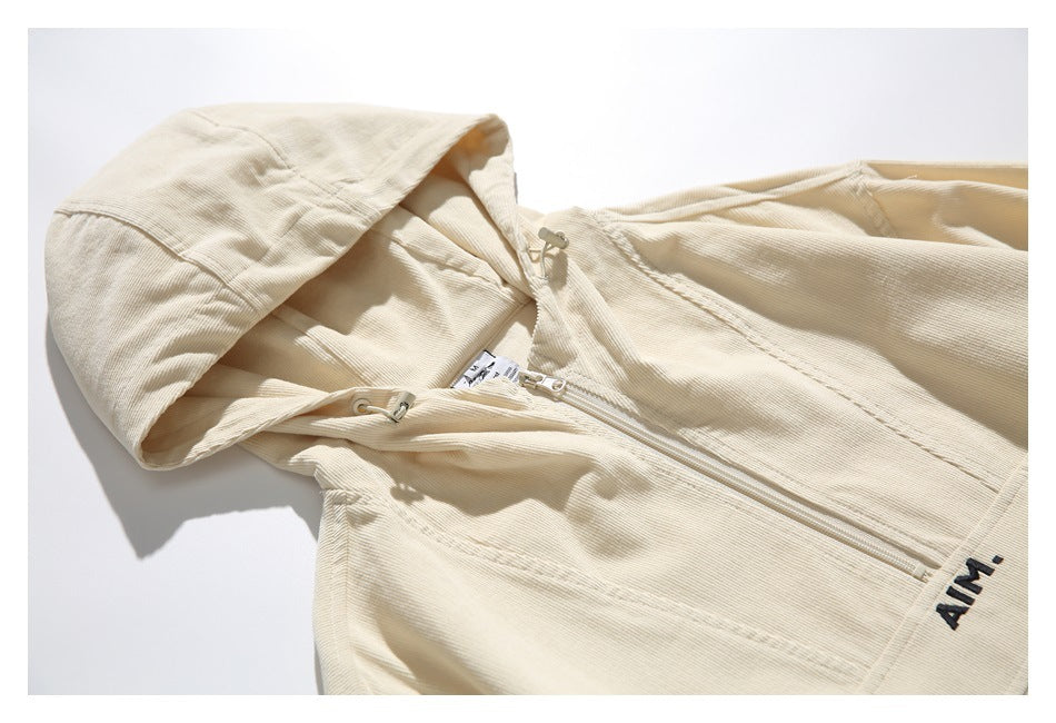 Angled close-up of the cream jacket’s hood, front zipper, drawcords, and black AIM lettering.