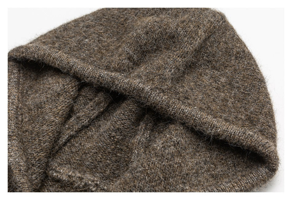 Close-up of a folded brown-gray knit garment with fuzzy yarn and a stitched edge.