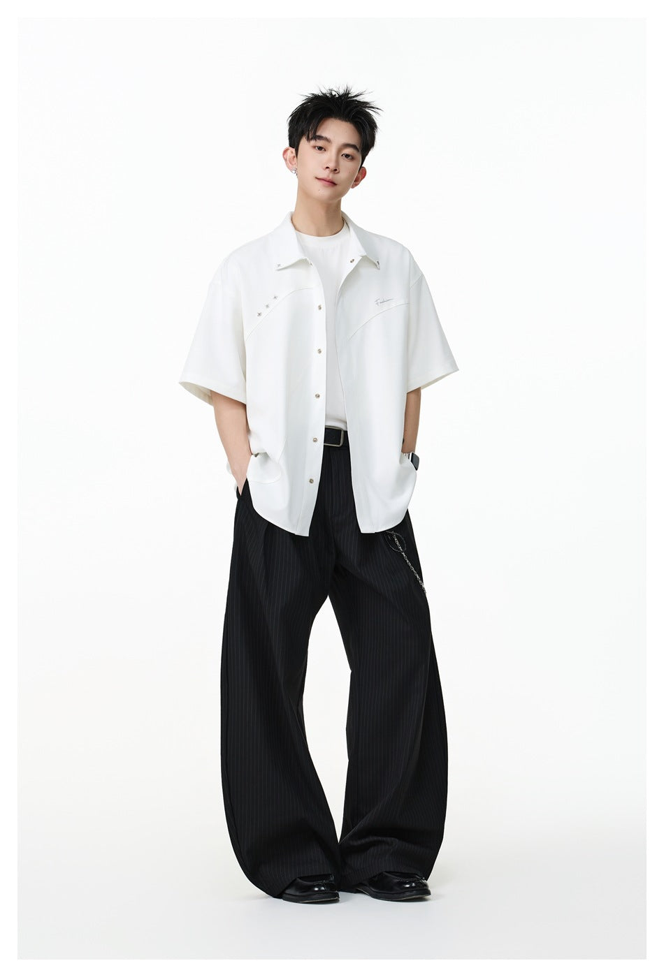 Full-length model wearing an oversized white short-sleeve button-up shirt with black wide-leg pinstripe trousers.