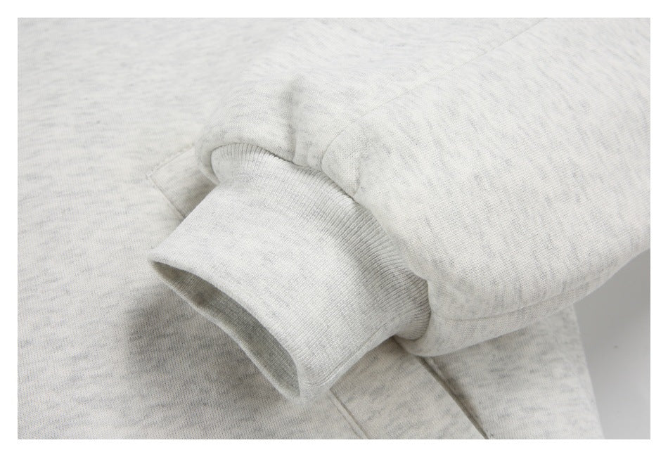 Close-up of the light gray hoodie’s ribbed sleeve cuff and stitching.