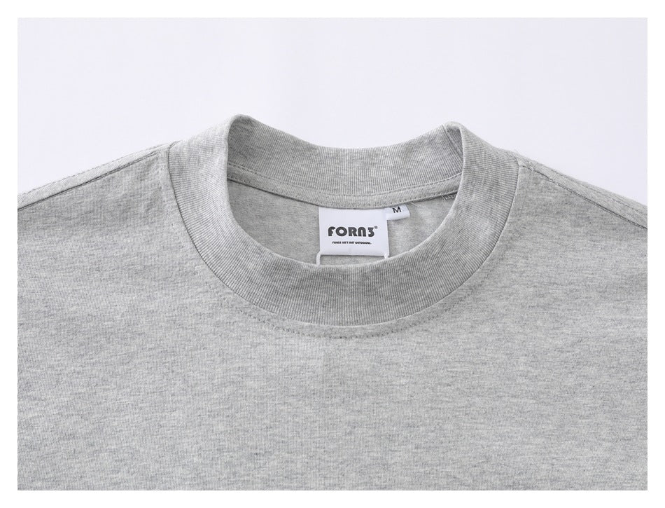 Close-up of a gray T-shirt crew neckline and sewn neck label showing size M.