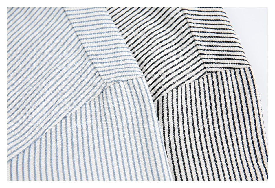 Close-up of overlapping white fabric panels with fine blue and black stripes.