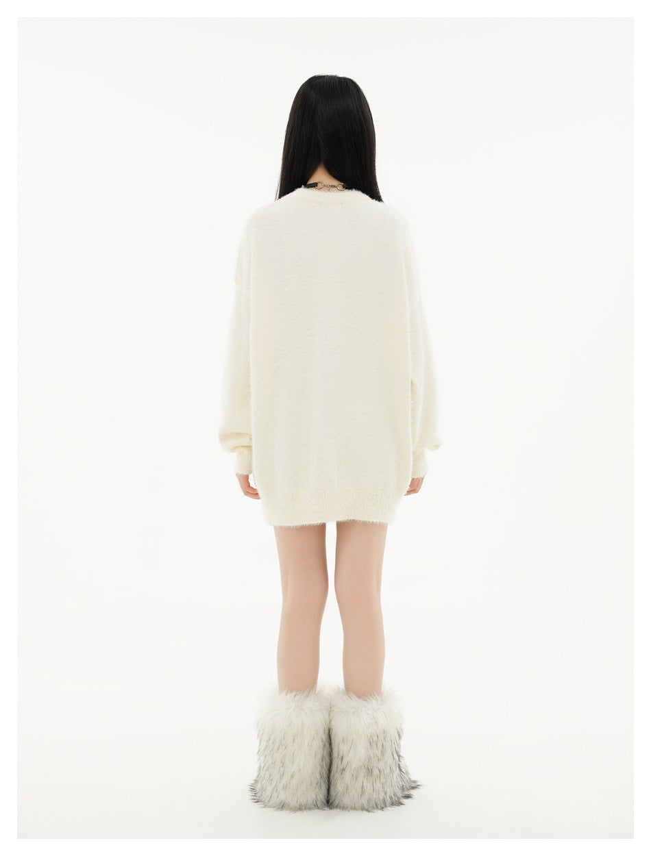 Back view of a model wearing the plain beige knit sweater with fuzzy white boots