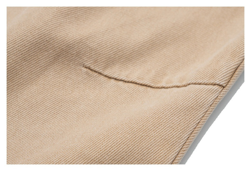 Close-up of a back pocket seam on beige twill trousers.