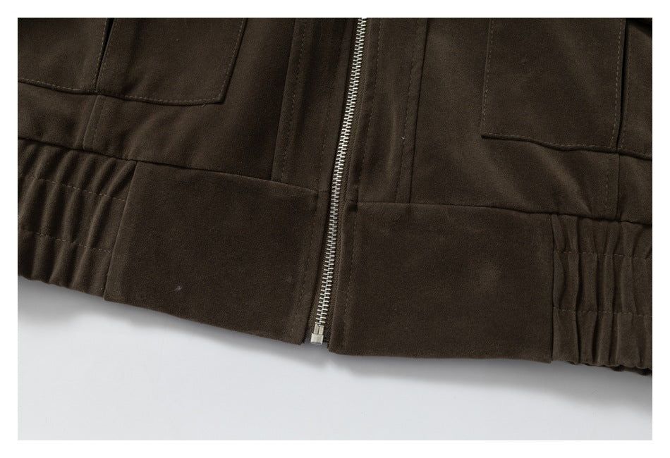 Close-up of the dark brown jacket's front zipper, lower panels, and gathered hem.