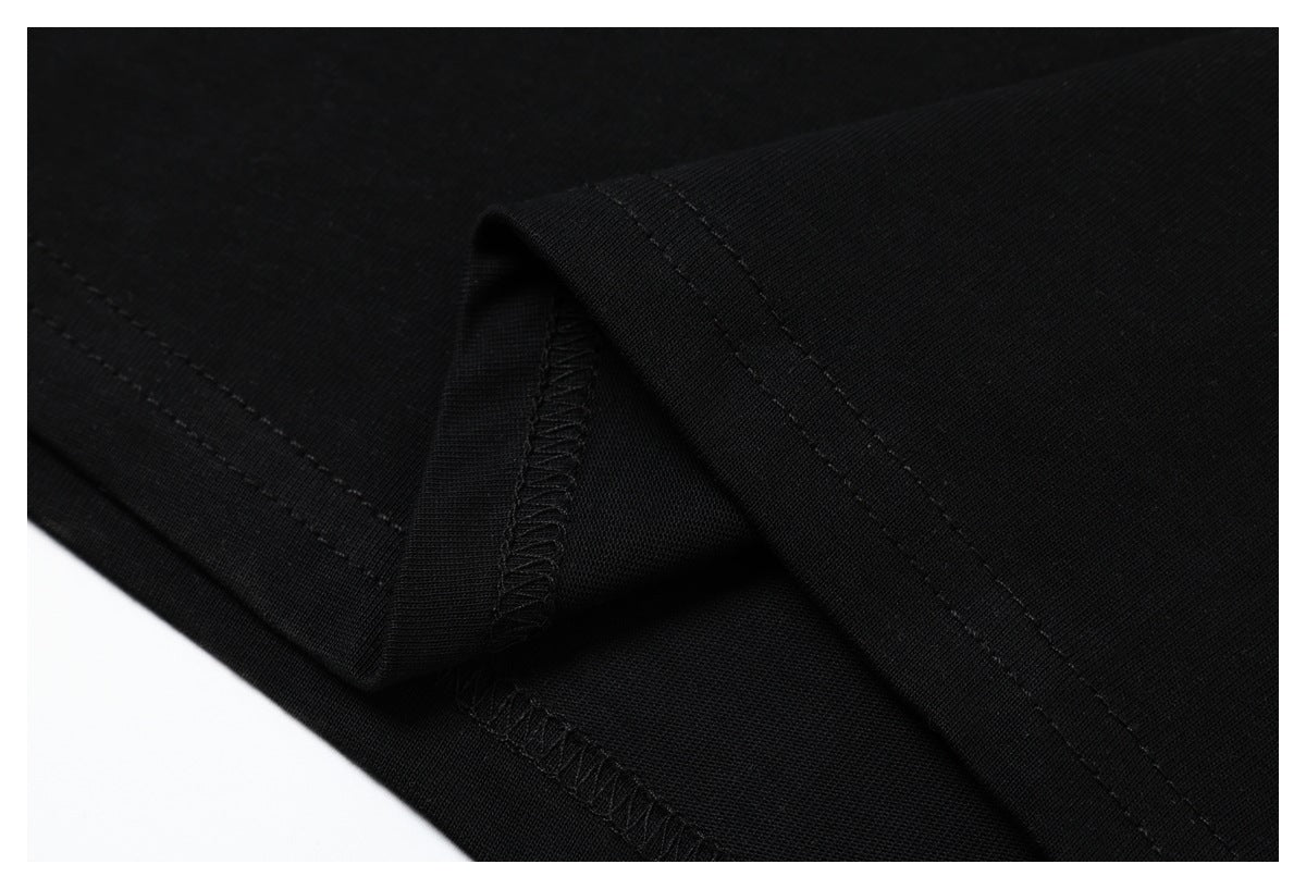 Close-up of black T-shirt fabric and stitched seams at a folded edge.