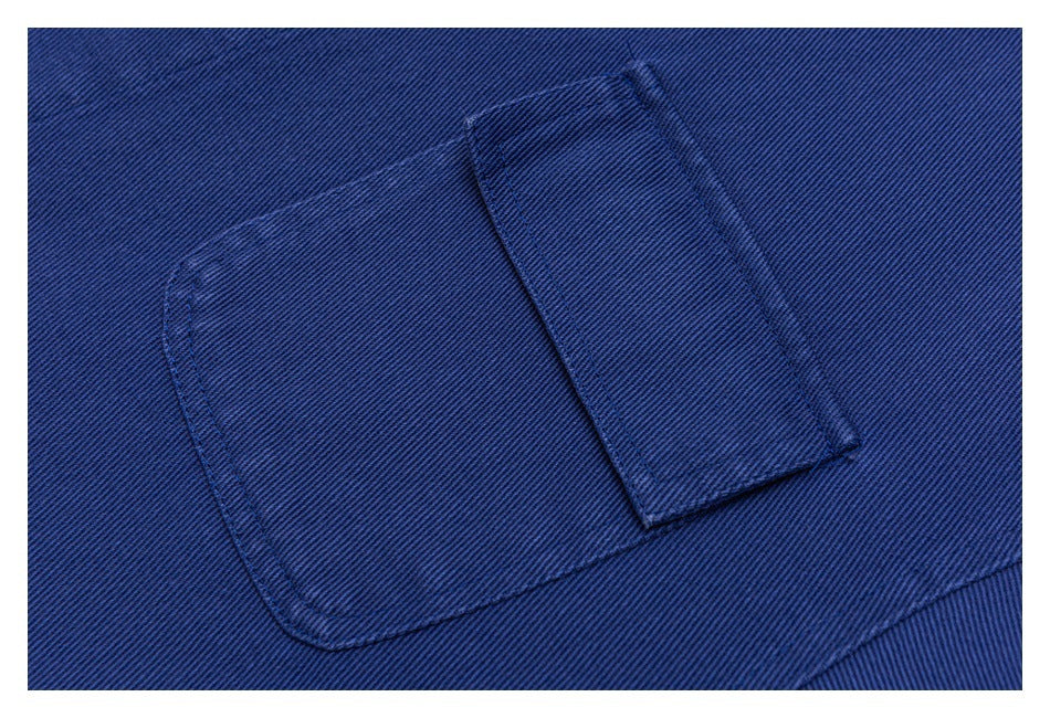 Close-up of a stitched blue jacket pocket with a rectangular flap.