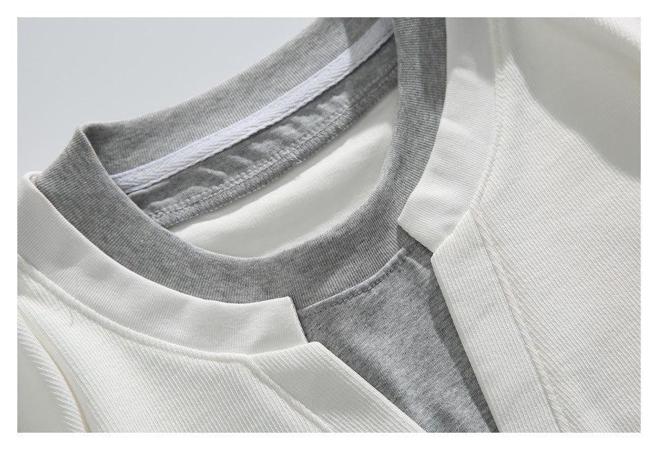 Close-up of a white ribbed garment neckline layered with a gray collar and inner panel.