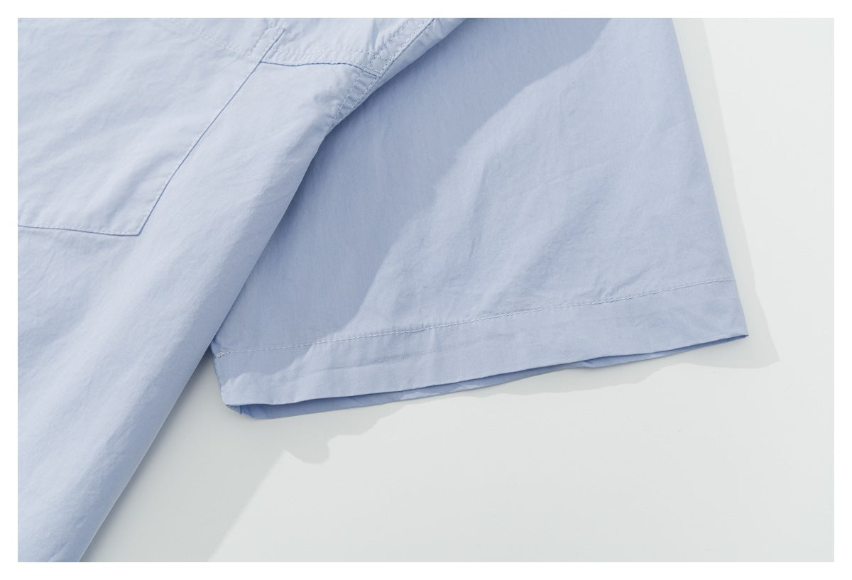 Close-up of the pale blue shirt's sleeve and neatly stitched hem.
