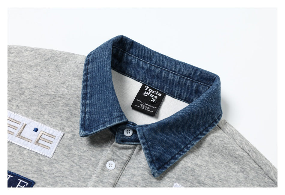 Close-up of a gray polo shirt with a blue denim-style collar, white buttons, and sewn patches.