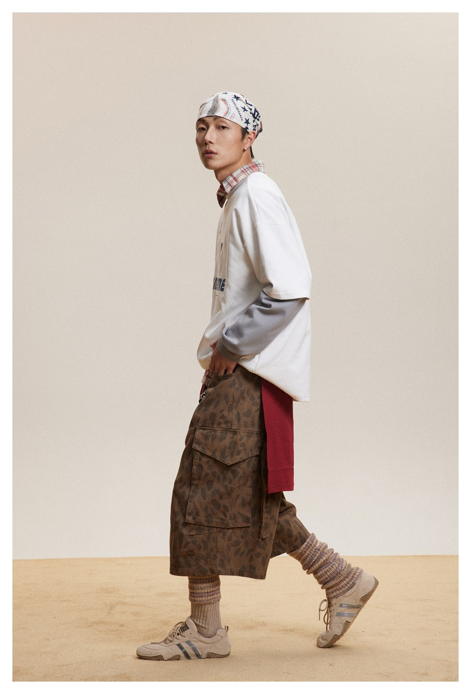 Model in a white oversized sweatshirt layered over gray sleeves, shown in a side-facing pose.
