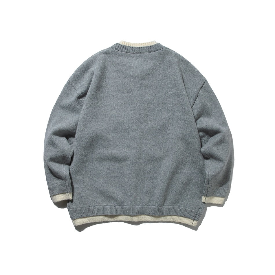 Back view of a gray knit cardigan with cream trim peeking at the collar, cuffs, and hem.
