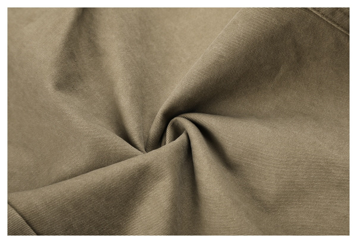 Close-up of taupe-brown fabric gathered into soft folds, showing a fine diagonal weave.