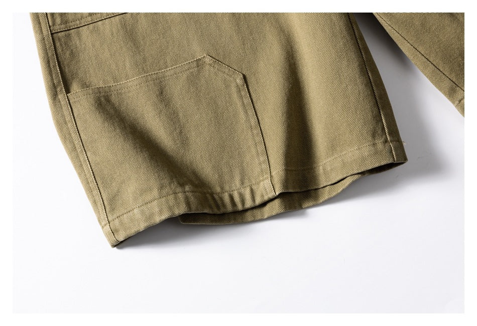 Close-up of a khaki trouser leg hem and rectangular patch pocket.
