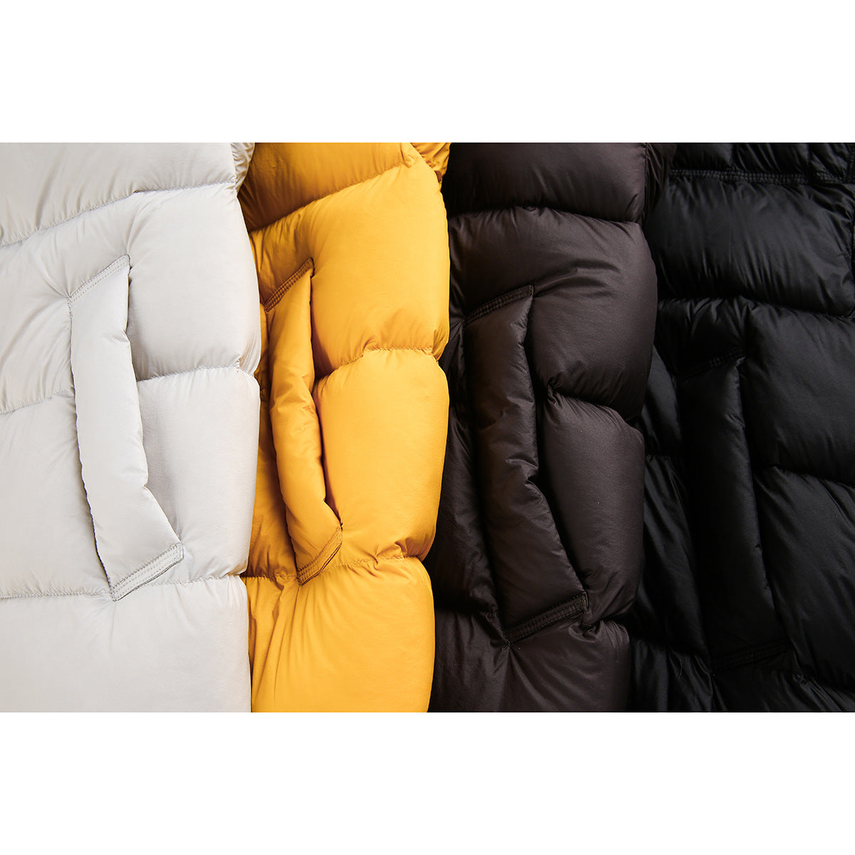 Close-up of padded jacket sections in white, yellow, dark brown and black, showing the quilting and pockets.