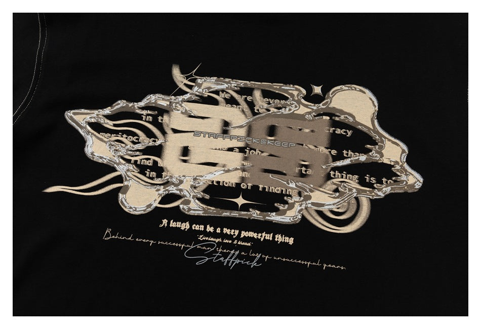 Close-up of a beige and gray graphic with English lettering printed on a black T-shirt.