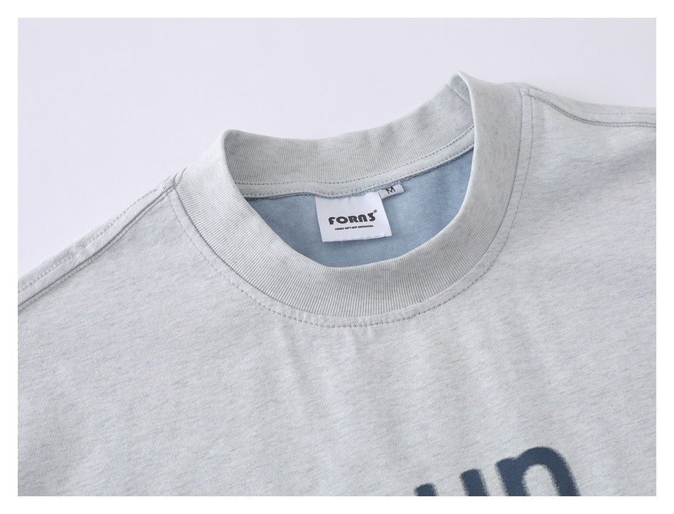 Close-up of the light gray T-shirt's ribbed crew neck and sewn-in label.