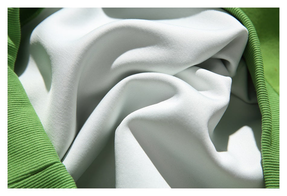 Close-up of white fabric framed by green ribbed trim, showing the fabric and edge construction.