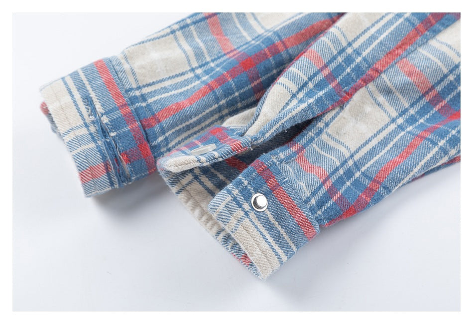 Close-up of the plaid shirt's snap-button cuff and long sleeve.