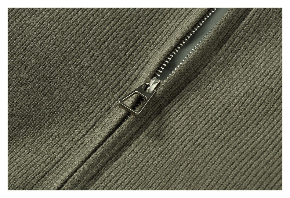 Close-up of a metal zipper and pull on olive-gray ribbed knit.