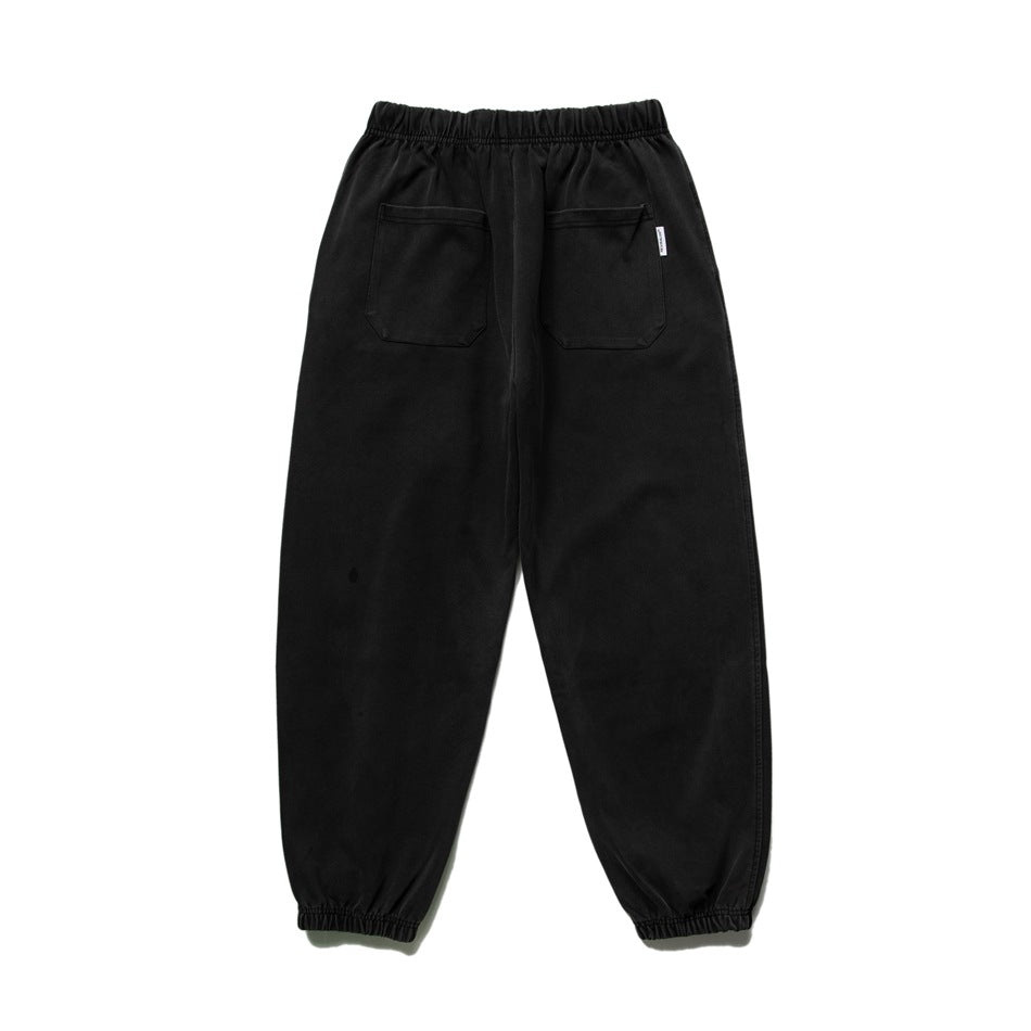 Back view of black joggers with an elastic waist, two patch pockets, and elastic cuffs.