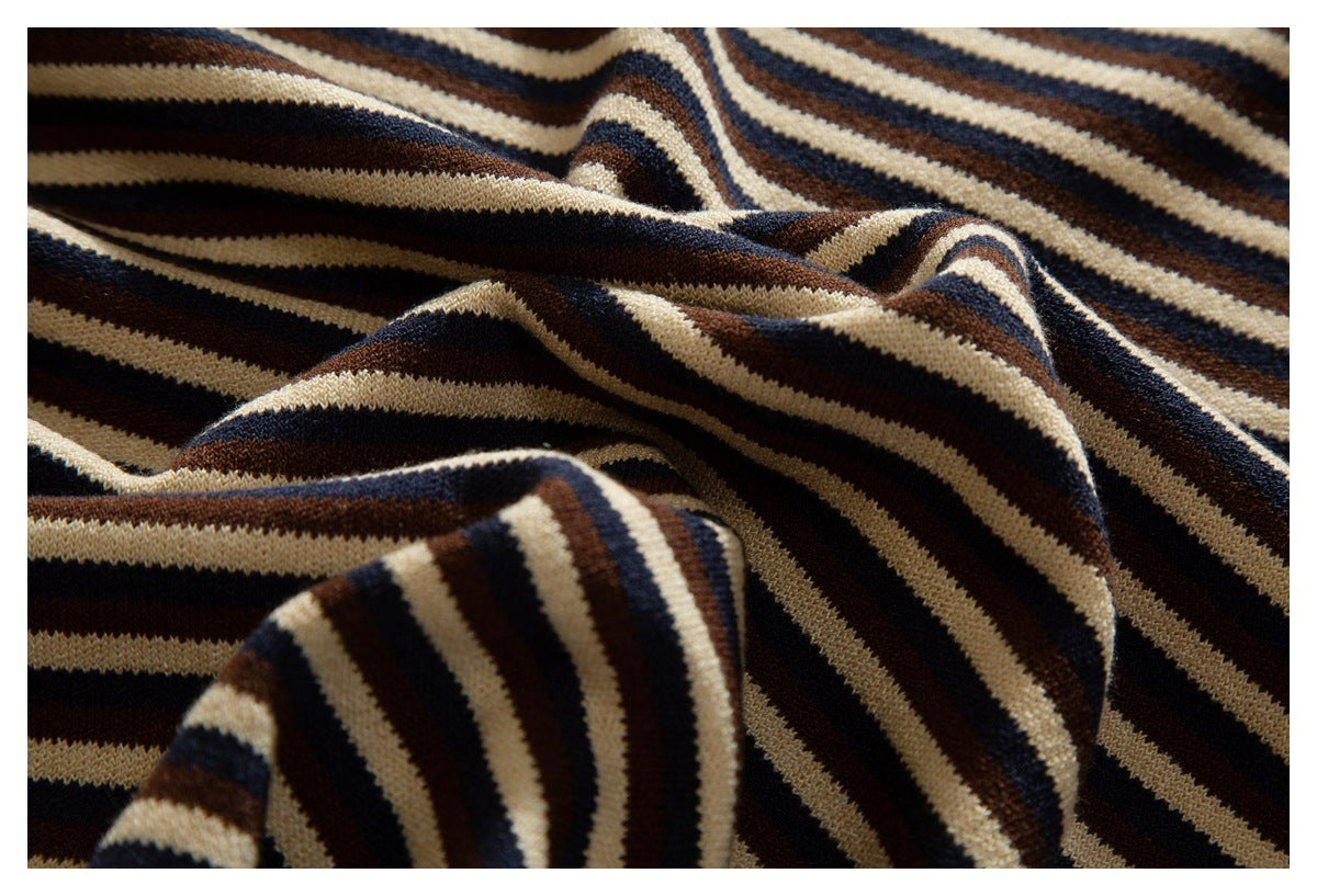 Close-up of folded striped knit fabric in cream, navy, and brown.