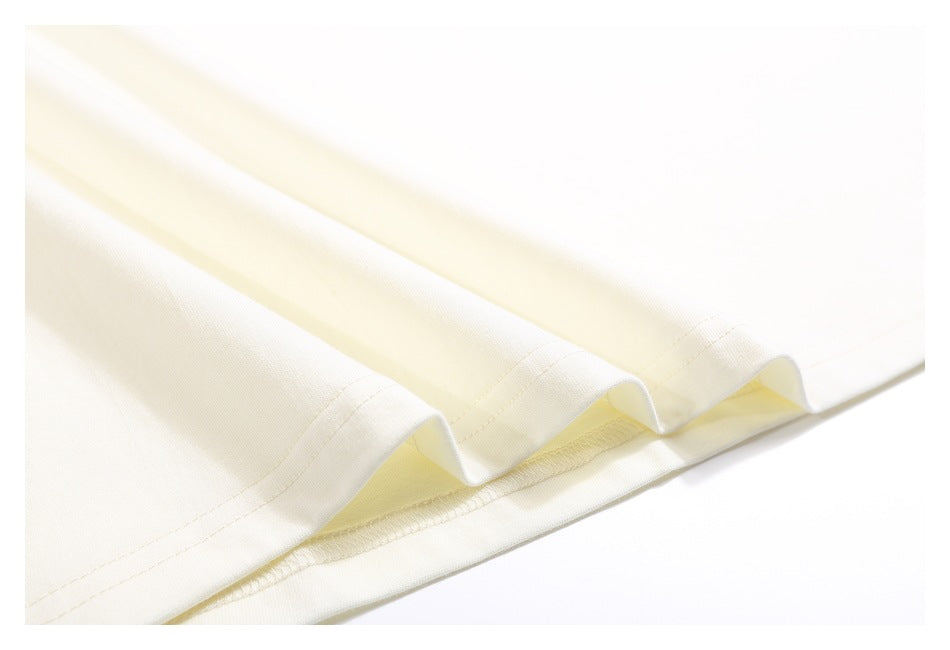 Close-up of the off-white T-shirt's folded bottom hem and stitching.