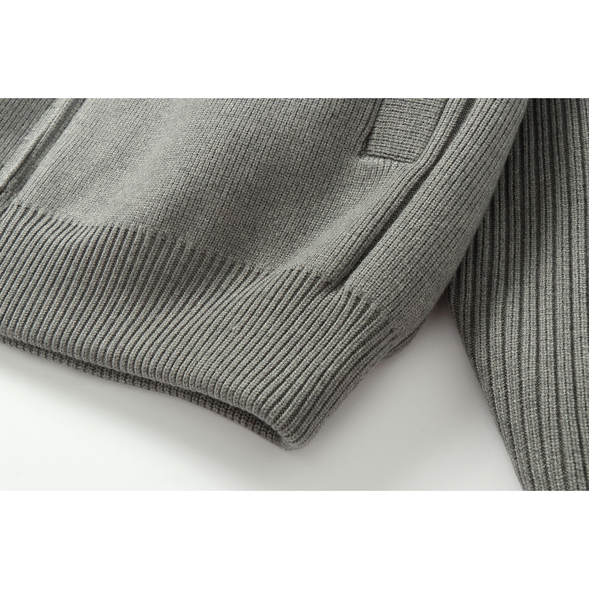 Close-up of the gray jacket's ribbed knit hem and sleeve.