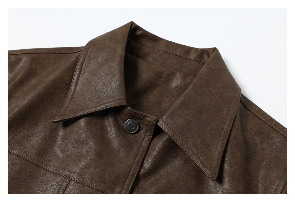 Close-up of a dark brown jacket's wide pointed collar and front snap against a light background.