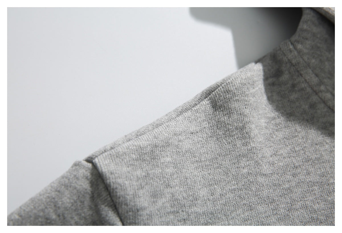 Close-up of the light gray hoodie's shoulder seam and fabric texture.