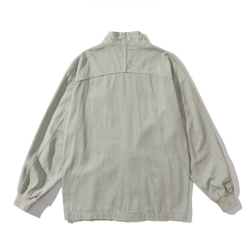 Back view of a light gray-green jacket with a band collar, shoulder seam and ribbed cuffs.