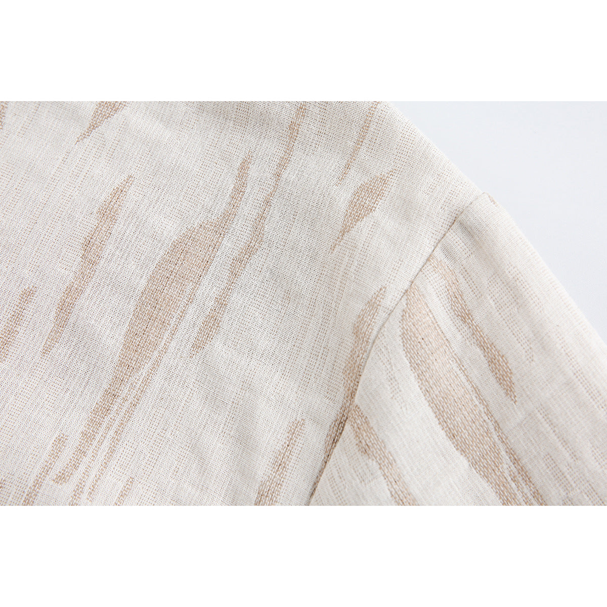 Close-up of the ivory jacket's tan woven pattern and shoulder seam.